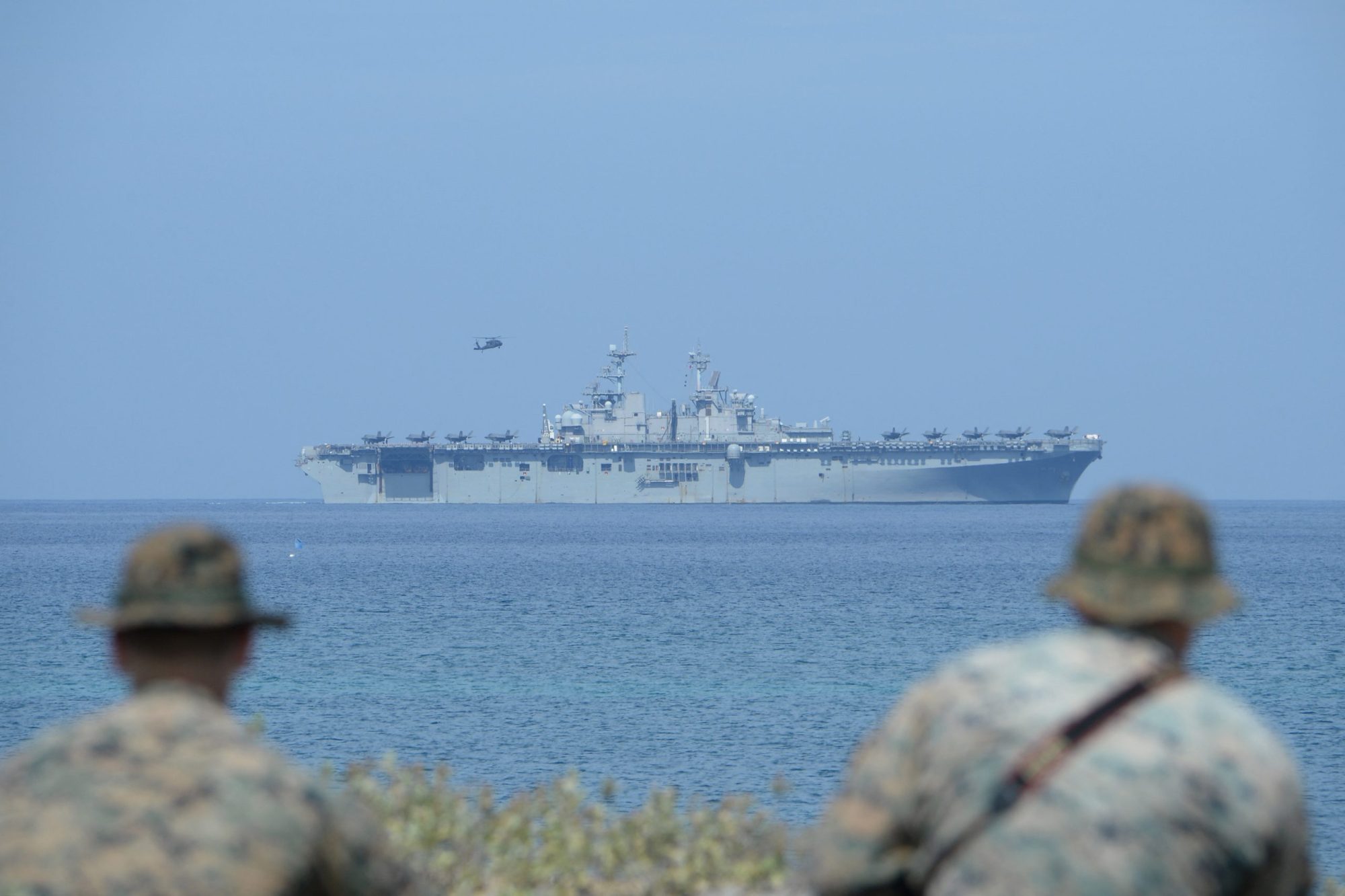 US Marines watch the US navy multipurpose amphibious assault ship 'USS Wasp' with F-35 lightning fighter jets on the deck during the amphibious landing exercises as part of the annual joint US-Philippines military exercise, on the shores of San Antonio town, facing the South China sea, Zambales province on April 11, 2019. Photo by TED ALJIBE/AFP via Getty Images