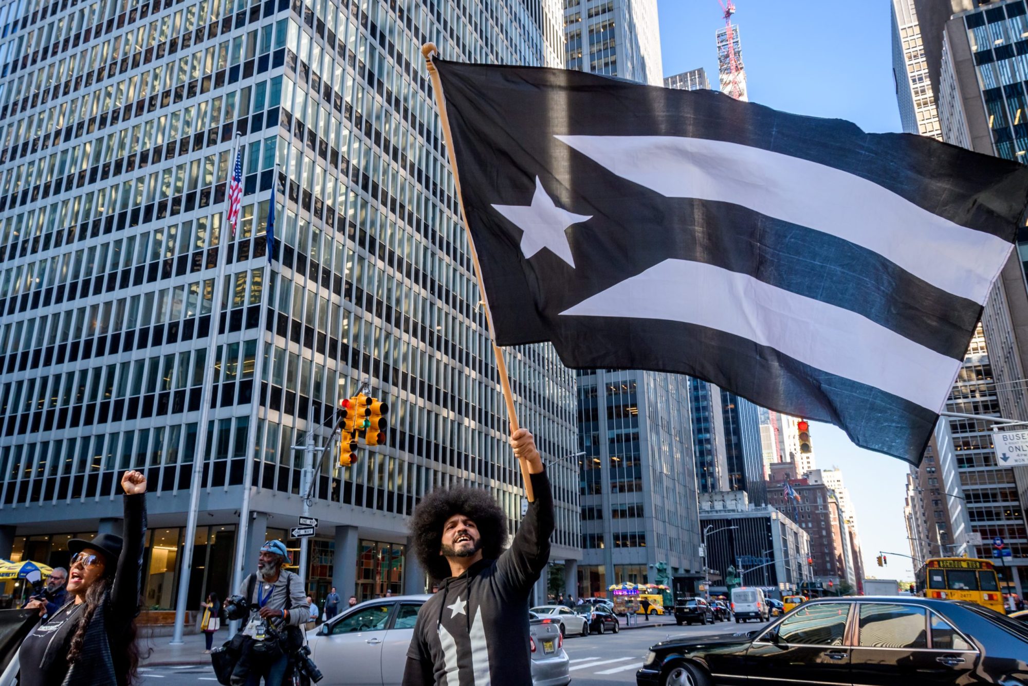 Protester holding a black Puerto Rican flag, a symbol of the mourning of the Puerto Rican Nation in colonial captivity. Photo by Erik McGregor/LightRocket via Getty Images