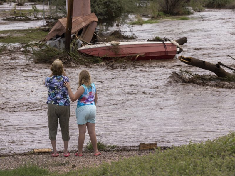In Roosevelt, Arizona, two residents look at possessions washed away by a flash flood