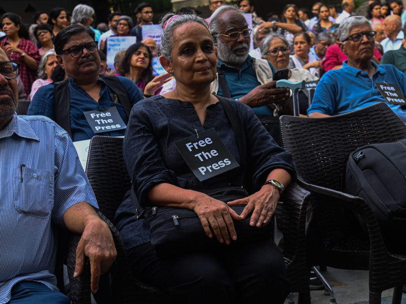 Indian Writer and Activist, Arundhati Roy (C), attends a protest against the raids of homes of journalists and writers belonging a news portal in New Delhi, India on October 04, 2023. Photo by Kabir Jhangiani/NurPhoto via Getty Images