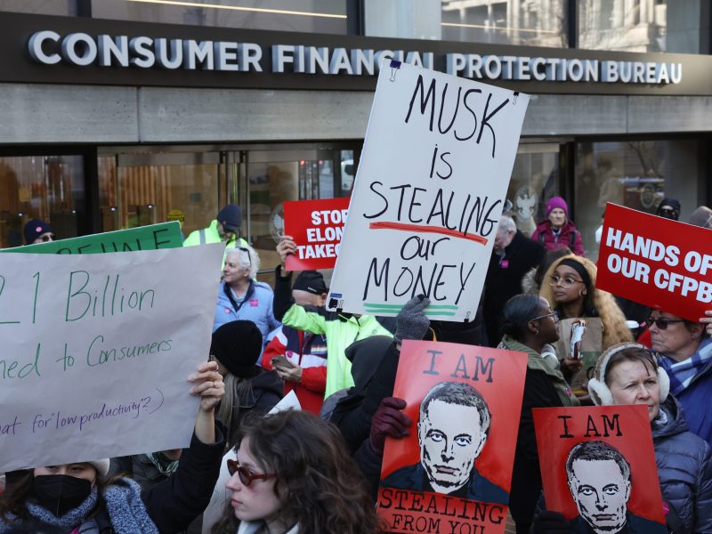 Demonstrators raise signs and posters as Congressional Democrats and CFPB workers hold a rally to protest the closing of the Consumer Financial Protection Bureau (CFPB) and the work-from-home order issued by CFPB Director Russell Vought outside its headquarters on February 10, 2025 in Washington, DC. Photo by Jemal Countess/Getty Images for MoveOn