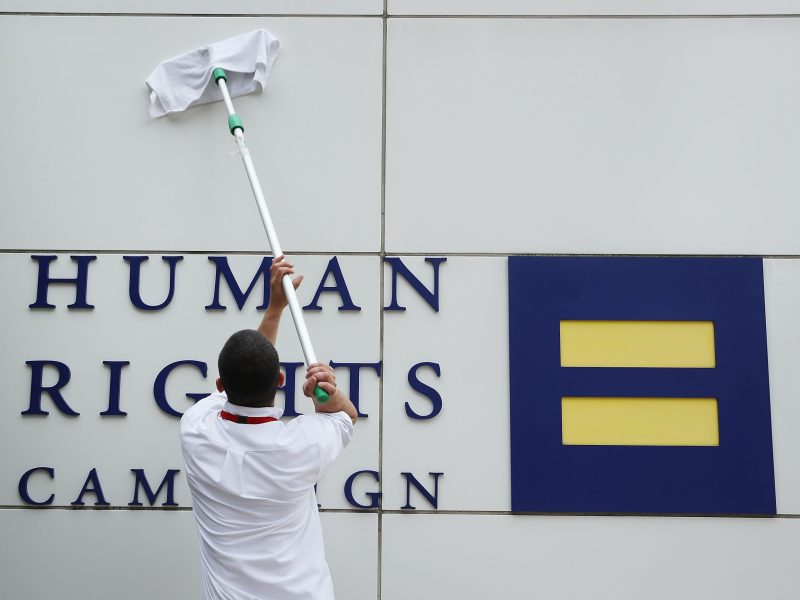 A worker cleans the wall of the Human Rights Campaign building