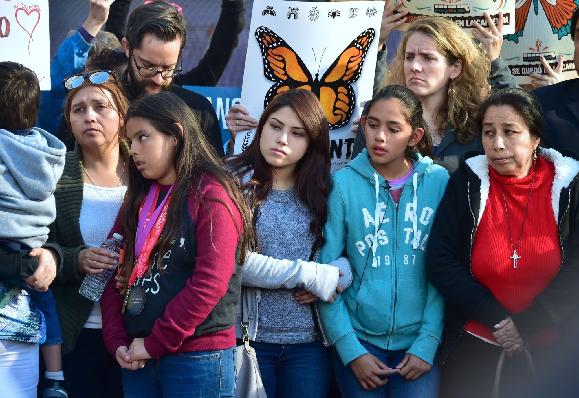 Yuleni (2nd-L), Jocelyn (C) and Fatima (2nd-R), US born daughters of undocumented Romulo Avelia-Gonzalez, who was arrested by ICE agents last week, and supporters attend a rally in downtown Los Angeles, California on March 6, 2017. Photo credit should read FREDERIC J. BROWN/AFP via Getty Images