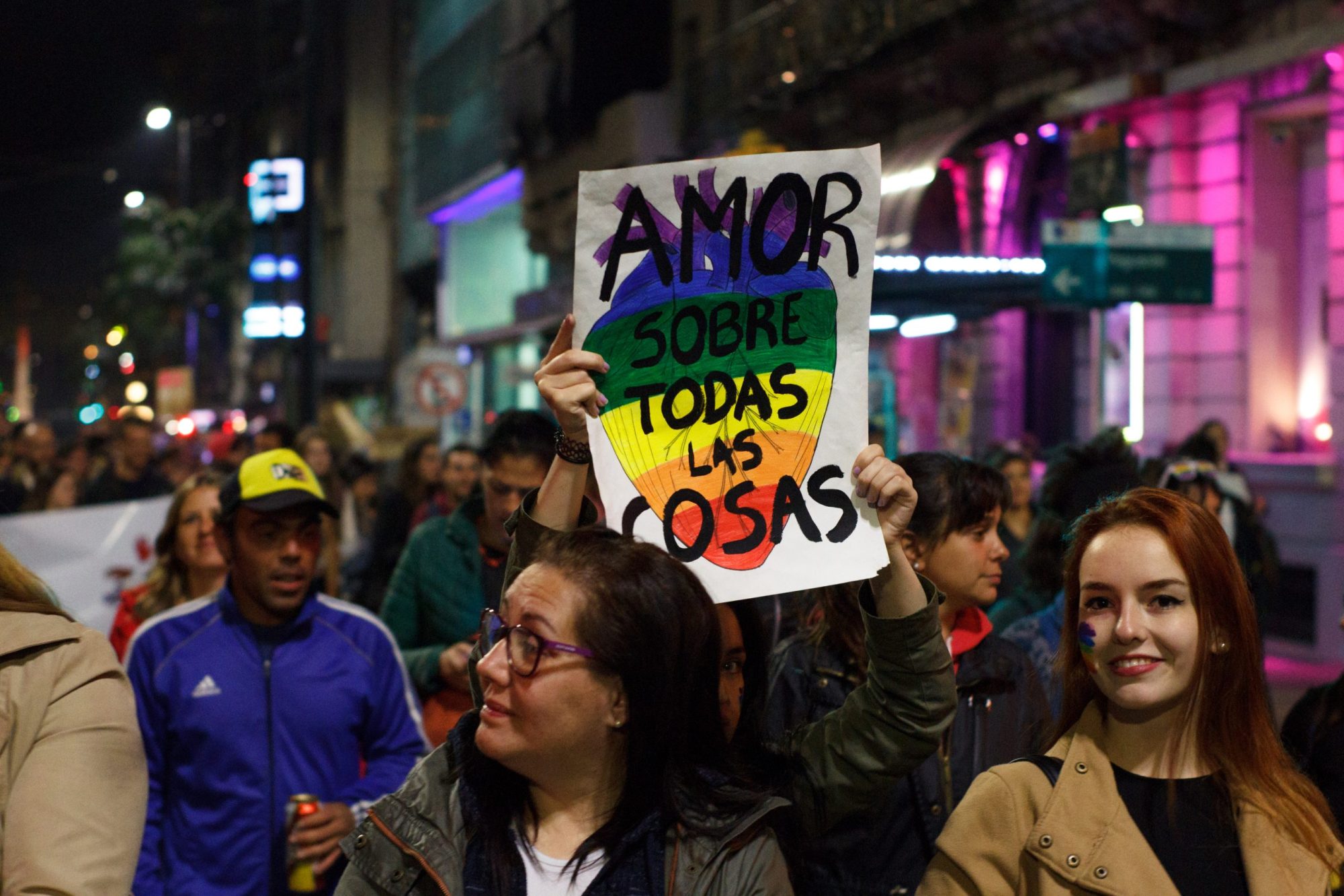 LGBT demonstrators shows a letter in spanish wich says "Love overall" during Montevideo's annual diversity march. Photo via Getty Images