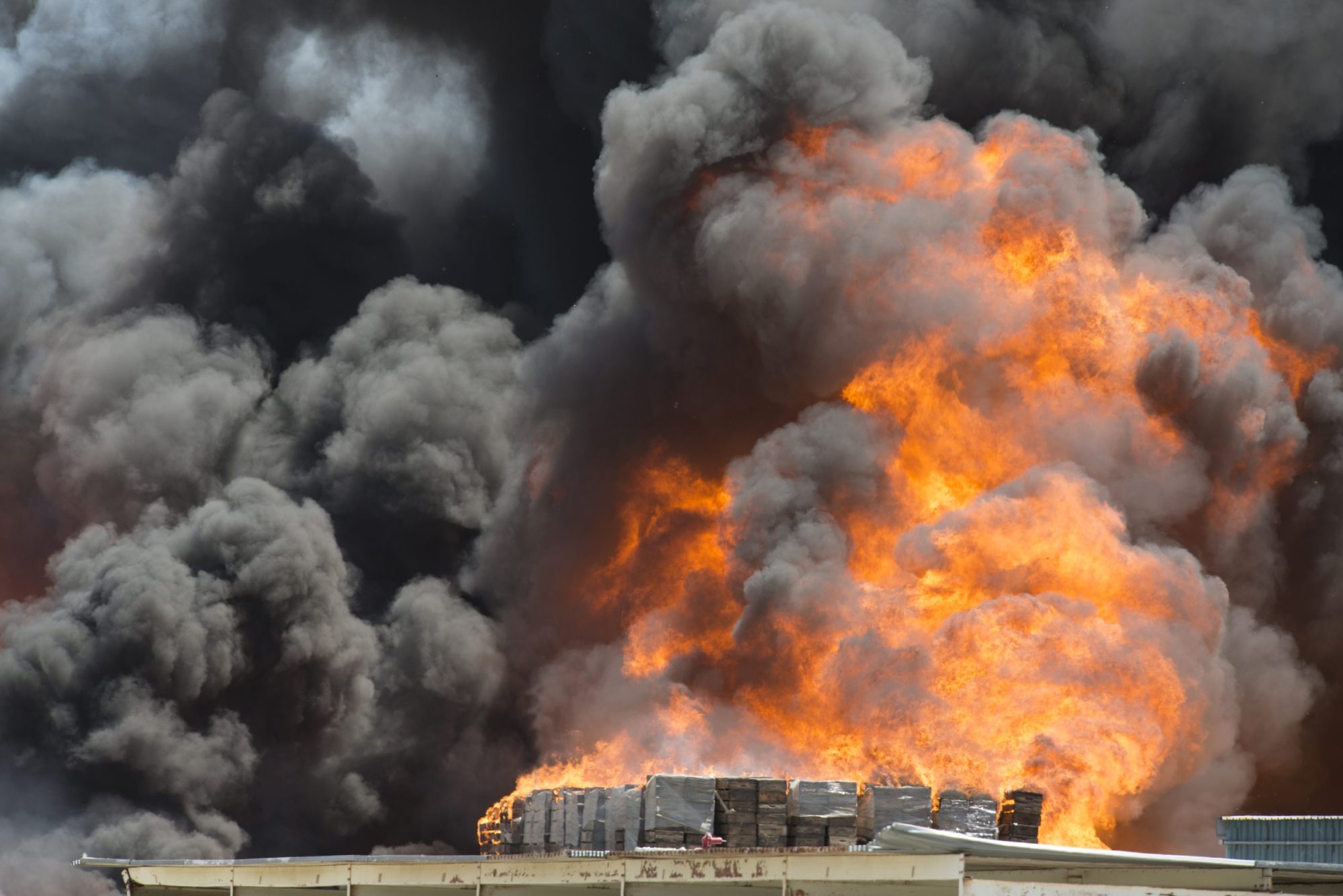 Smoke emitting from burning crates in factory. Photo via Getty Images