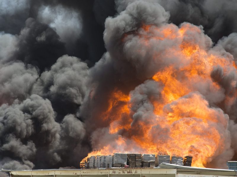 Smoke emitting from burning crates in factory. Photo via Getty Images