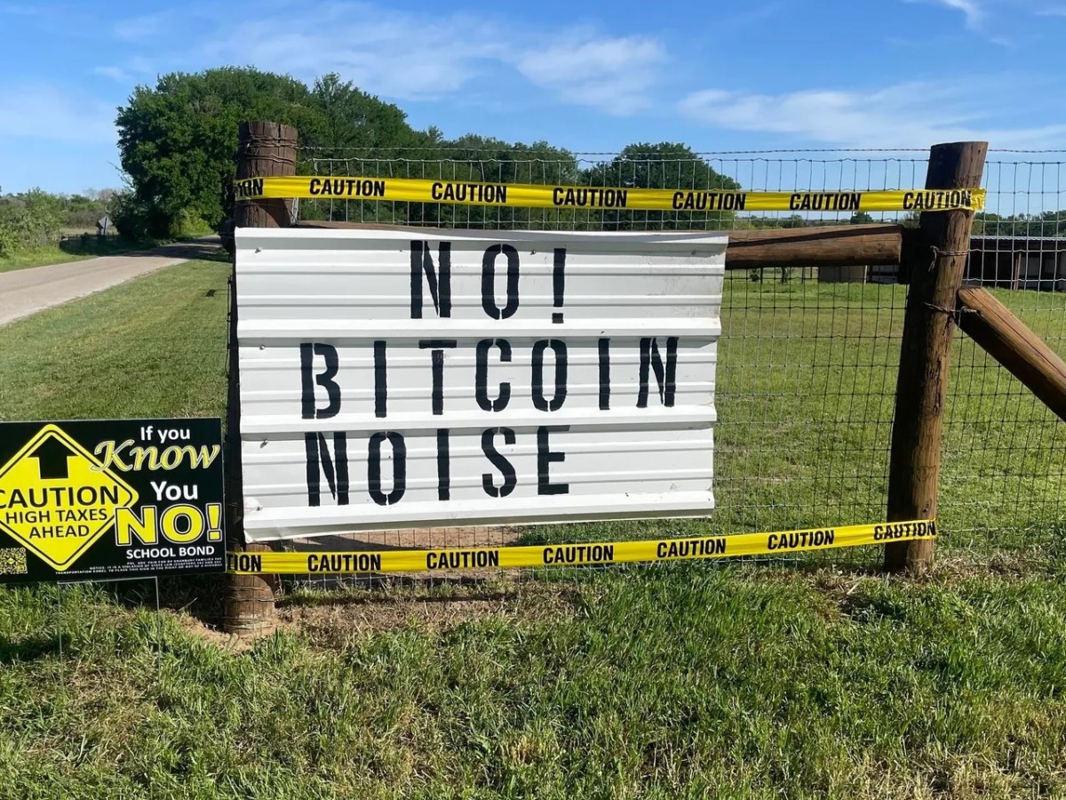 A sign on residential property in Granbury, TX, leans against a wooden fence. The sign says "No! Bitcoin Noise." Photo courtesy of Protect Hood County.