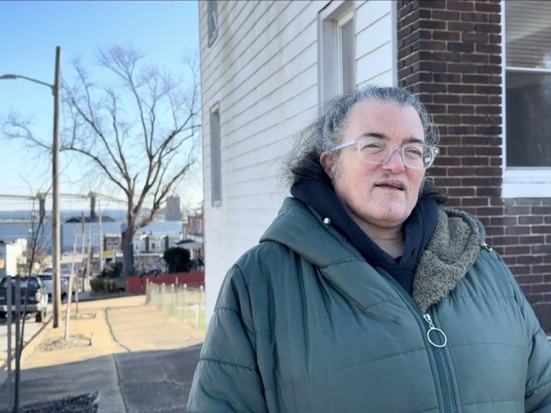 Angela "Angie" Shaneyfelt stands next to her home in Curtis Bay, South Baltimore, Maryland, with the CSX Transportation coal export terminal—which operates about 1,000 feet away from her residence—visible in the background. Photo taken by Maximillian Alvarez on Dec. 12, 2024.